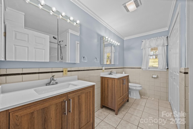 bathroom featuring ornamental molding, two vanities, tile patterned flooring, and a sink