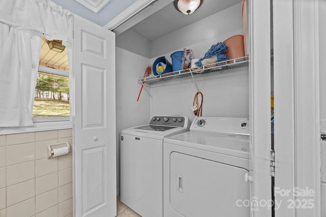 laundry area featuring laundry area, independent washer and dryer, and tile walls