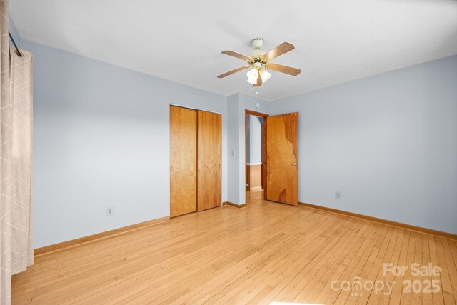 unfurnished bedroom featuring a closet, wood-type flooring, ceiling fan, and baseboards