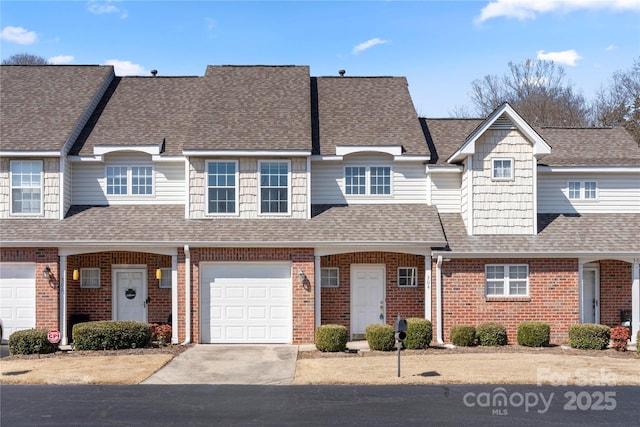 multi unit property with driveway, a shingled roof, and brick siding