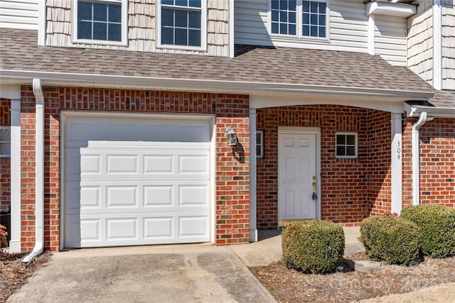 view of exterior entry featuring a shingled roof and brick siding