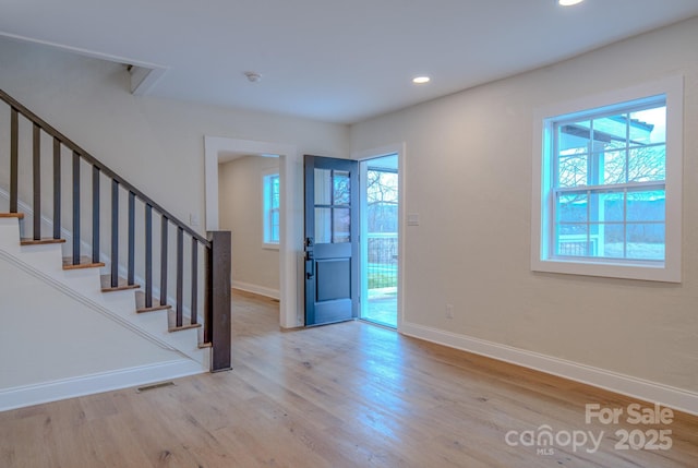 entryway with baseboards, visible vents, wood finished floors, stairs, and recessed lighting