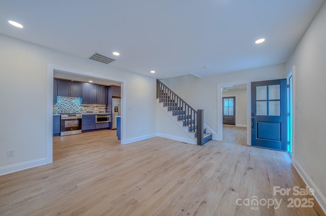 interior space featuring light wood-style flooring, stairs, visible vents, and recessed lighting