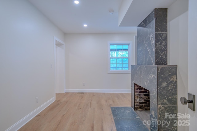 unfurnished living room with recessed lighting, baseboards, and wood finished floors