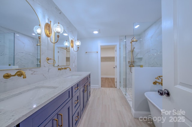 full bath with double vanity, a sink, a freestanding bath, and a walk in shower