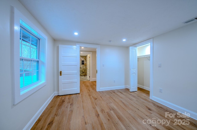 empty room with recessed lighting, baseboards, visible vents, and light wood finished floors