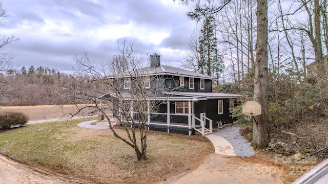 view of front of home featuring a chimney and a front lawn