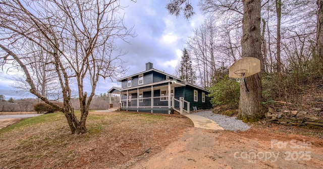 chalet / cabin featuring a porch and a chimney