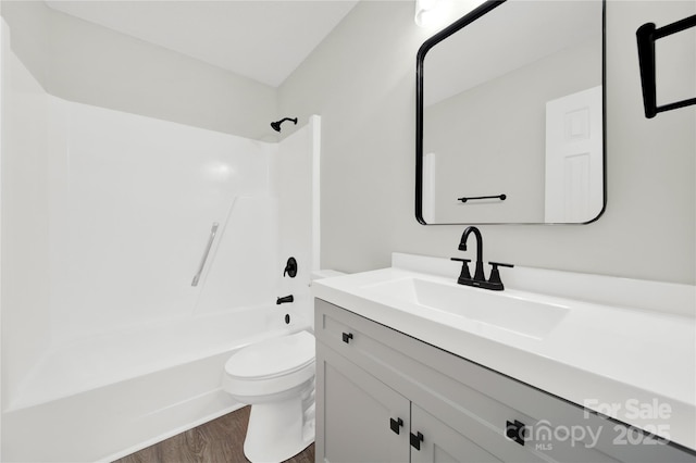 bathroom with vanity, shower / tub combination, wood finished floors, and toilet