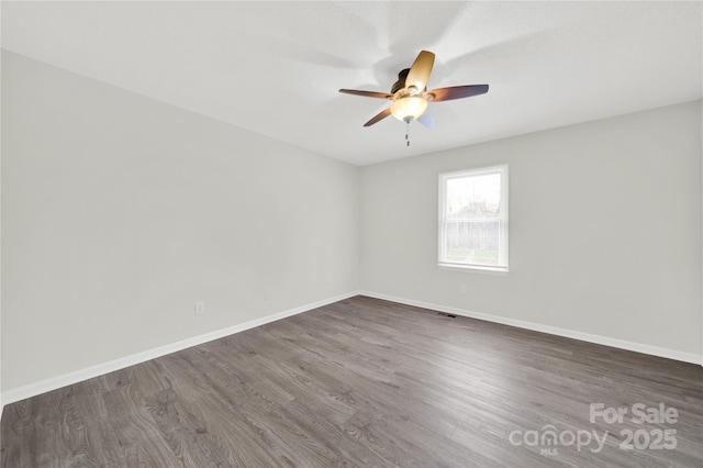 spare room with visible vents, ceiling fan, baseboards, and wood finished floors