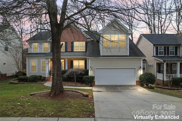 view of front of home featuring driveway, an attached garage, and a front yard