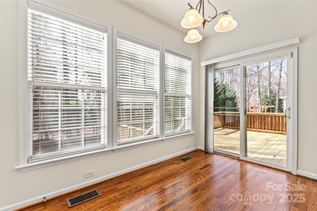 interior space with visible vents, baseboards, and wood finished floors