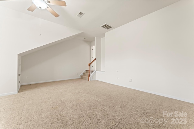 empty room featuring baseboards, visible vents, a ceiling fan, and light colored carpet