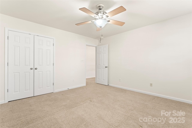 unfurnished bedroom featuring carpet floors, ceiling fan, baseboards, and a closet