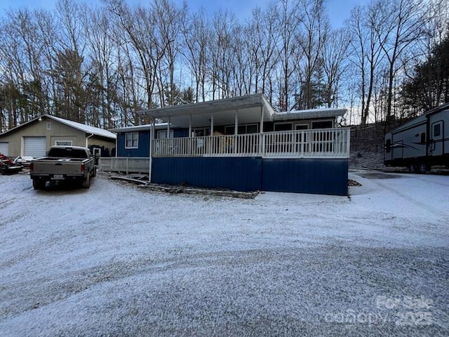 view of front facade with a garage, covered porch, and an outdoor structure