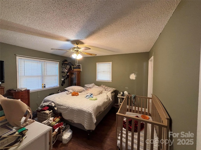 bedroom with a textured ceiling, a ceiling fan, and wood finished floors