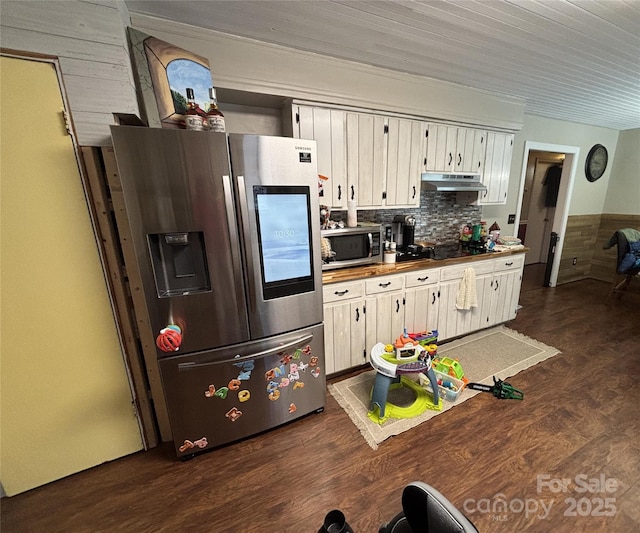 kitchen with under cabinet range hood, backsplash, stainless steel appliances, and dark wood-style flooring