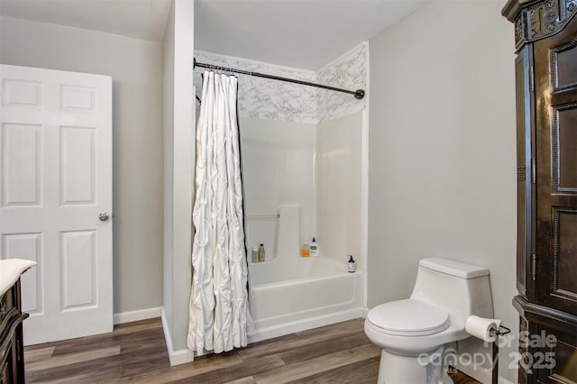 bathroom with shower / bath combo, baseboards, toilet, wood finished floors, and vanity