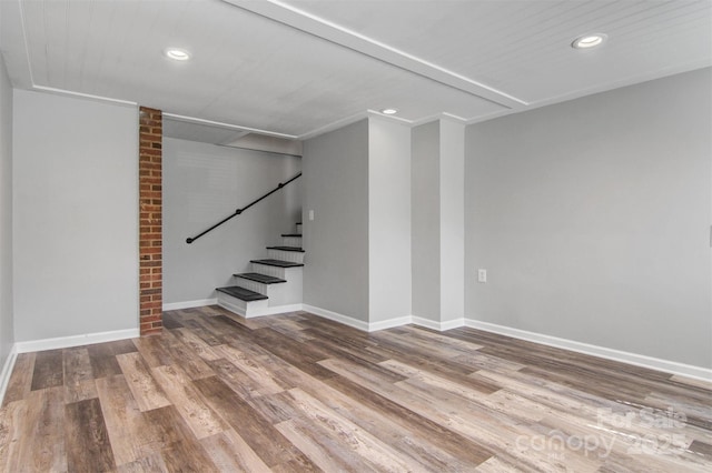 below grade area with stairs, baseboards, wood finished floors, and recessed lighting