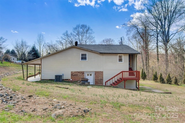 rear view of house featuring central AC unit and brick siding