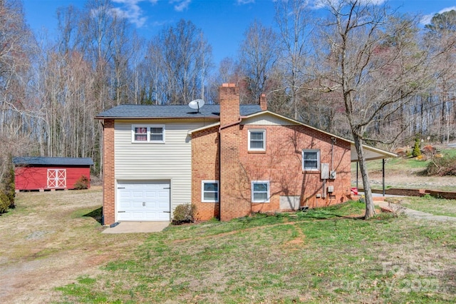 rear view of house with an attached garage, brick siding, a yard, driveway, and a chimney