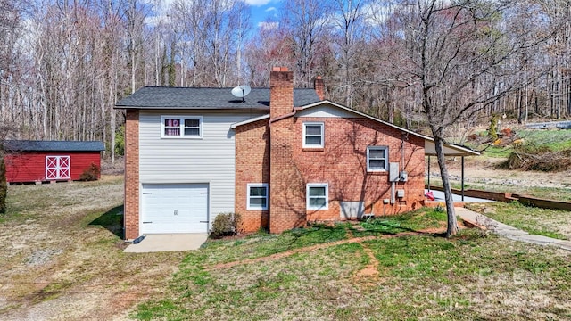 back of property featuring a chimney, an attached garage, a yard, a shed, and brick siding