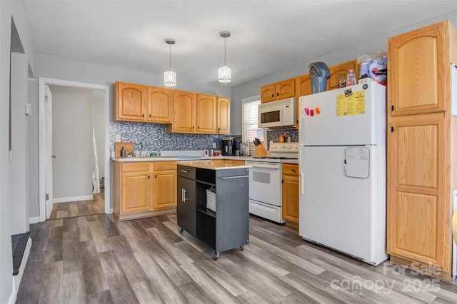 kitchen featuring white appliances, tasteful backsplash, wood finished floors, light countertops, and pendant lighting