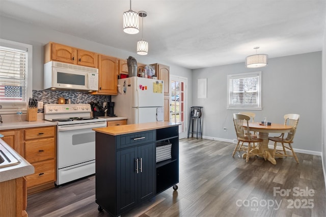 kitchen with dark wood-style flooring, decorative light fixtures, light countertops, backsplash, and white appliances