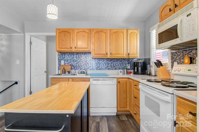 kitchen featuring white appliances, dark wood-style flooring, a sink, decorative backsplash, and decorative light fixtures