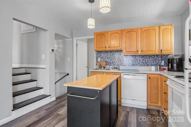 kitchen featuring white appliances, dark wood finished floors, backsplash, and a sink