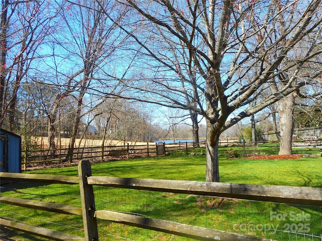 view of yard featuring a water view and fence