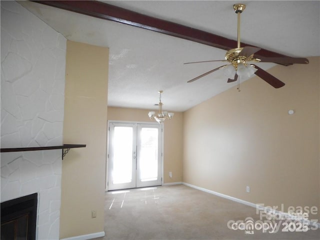 unfurnished living room featuring carpet, a fireplace, lofted ceiling with beams, and baseboards