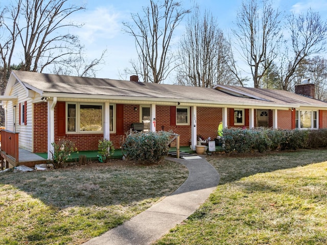 single story home featuring covered porch, brick siding, a chimney, and a front lawn