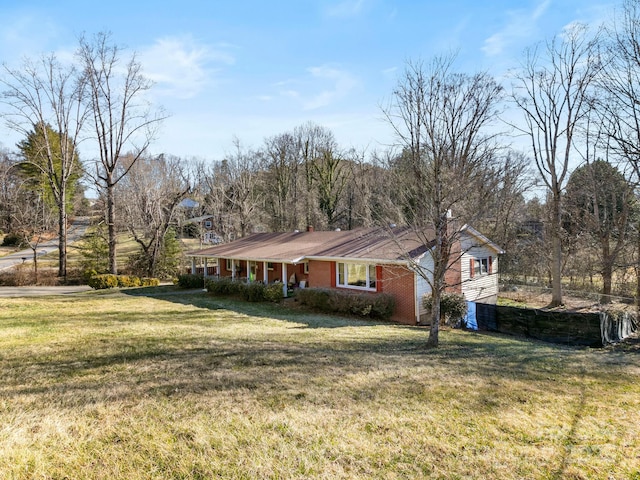 exterior space with brick siding, a chimney, and a front yard