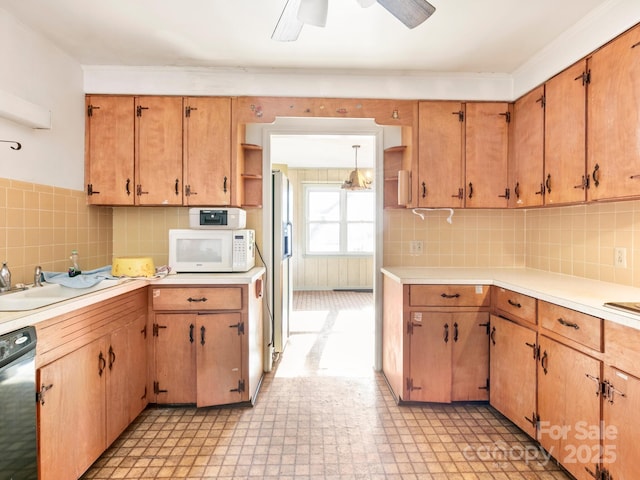 kitchen with light floors, light countertops, stainless steel dishwasher, white microwave, and fridge with ice dispenser