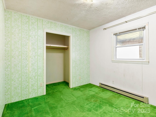 unfurnished bedroom with wallpapered walls, a baseboard heating unit, a textured ceiling, and carpet flooring