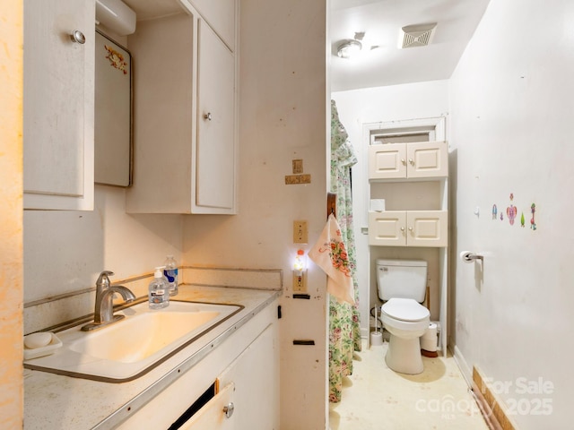 full bath with baseboards, visible vents, vanity, and toilet