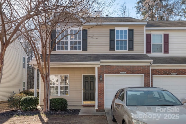 view of front of property with a garage, brick siding, and a shingled roof