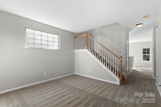 stairs featuring baseboards and carpet