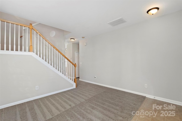 empty room featuring visible vents, carpet, stairs, and baseboards