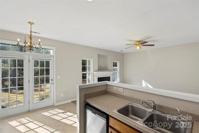 kitchen with visible vents, a fireplace, a sink, dishwasher, and decorative light fixtures