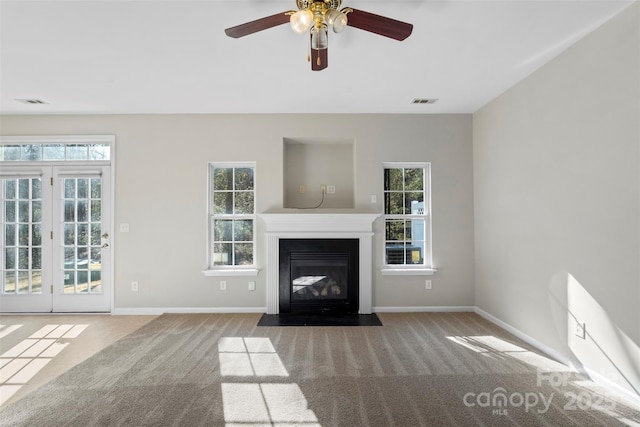 unfurnished living room with baseboards, a fireplace with flush hearth, visible vents, and carpet flooring