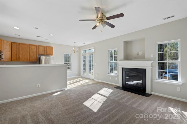 unfurnished living room with visible vents, light colored carpet, baseboards, and a fireplace with flush hearth