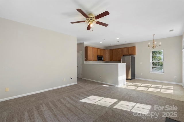 unfurnished living room featuring visible vents, baseboards, light carpet, recessed lighting, and ceiling fan with notable chandelier