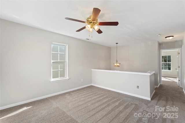 empty room with a ceiling fan, baseboards, and carpet floors