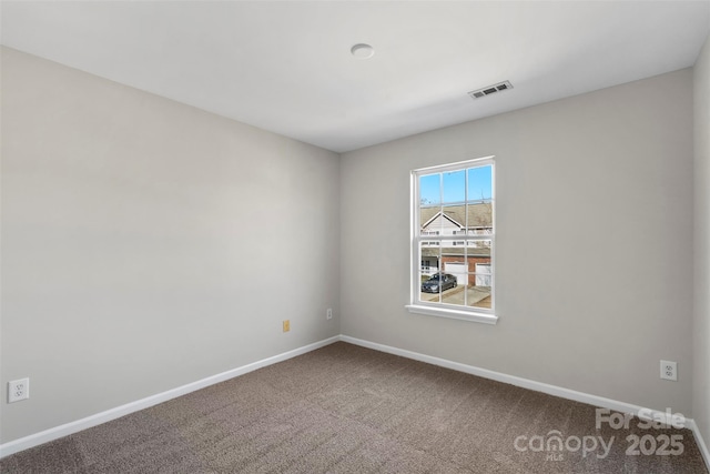 empty room featuring visible vents, baseboards, and carpet