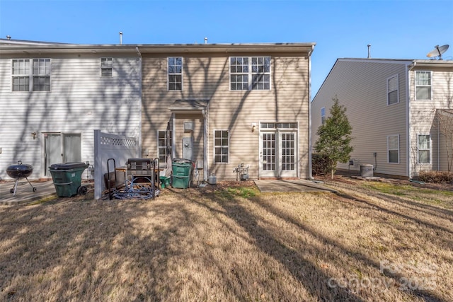 rear view of house featuring a patio, a lawn, and central AC