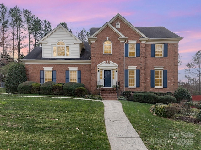 view of front of property featuring a front yard and brick siding