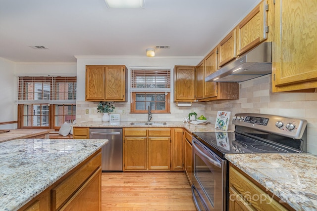 kitchen with stainless steel appliances, visible vents, a sink, and under cabinet range hood