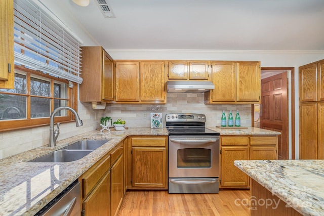 kitchen featuring under cabinet range hood, crown molding, stainless steel appliances, and a sink